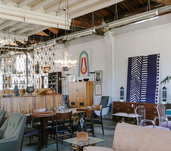 Chairs, lamps and artwork on display in a vintage store.