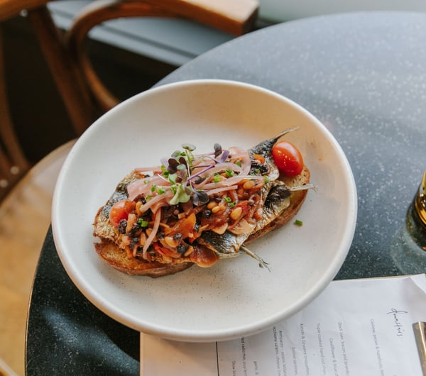Sardines on toast on a table.