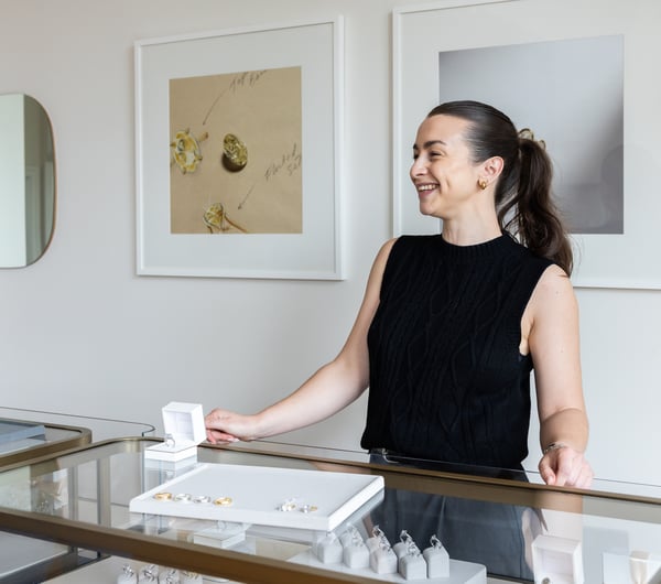 Shop assistant behind a jewellery counter.