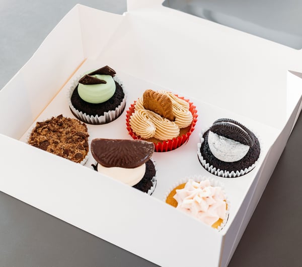 Colourful cupcakes in a white box.