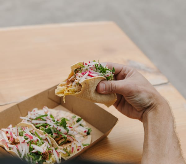 A hand holding a taco.