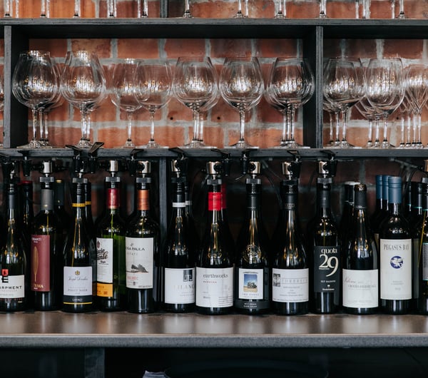 Bottles of red wine lined up in a row on a table.