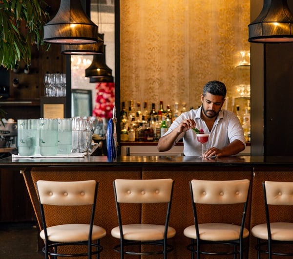 A man making a cocktail at a bar.