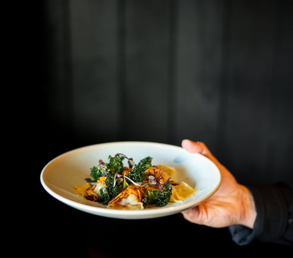A hand holding a plate of food.