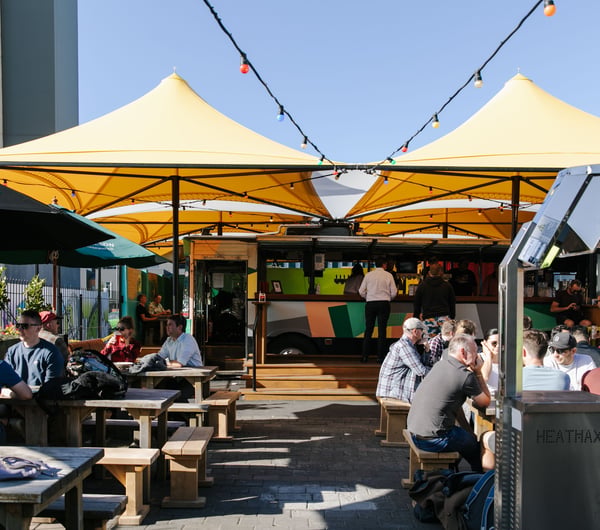 Lots of people sitting around tables at Smash Palace Christchurch on a sunny day.