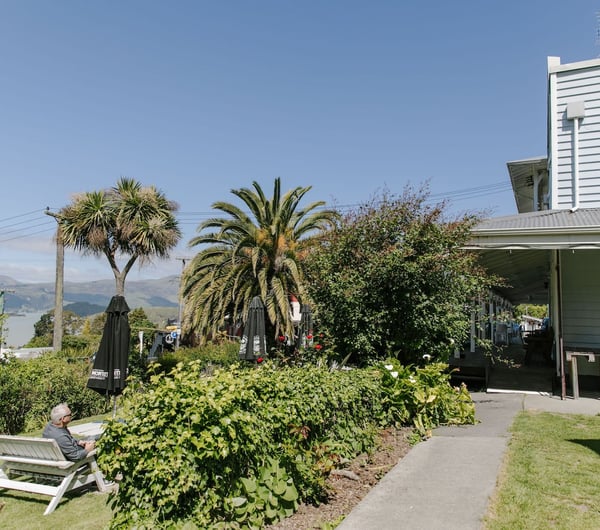 Lush garden area at Ōtoromiro Hotel in Governor's Bay overlooking water and hills