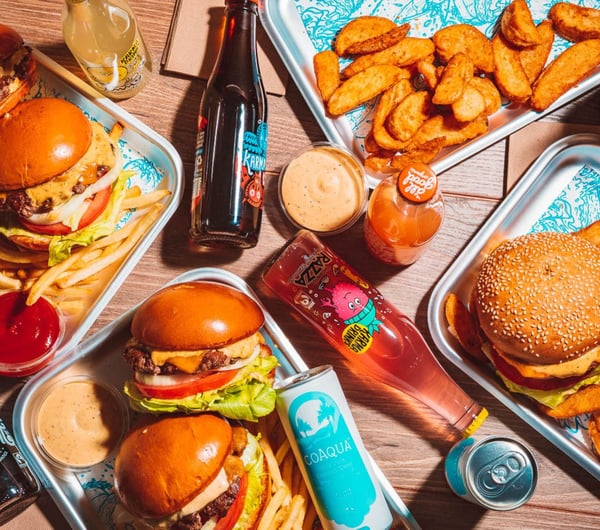 Birds eye view of silver trays filled with burgers and fries.