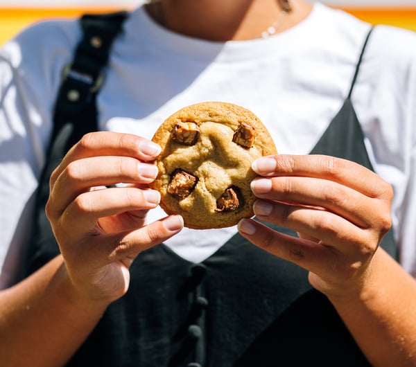 A woman holding a cookie in two hands.