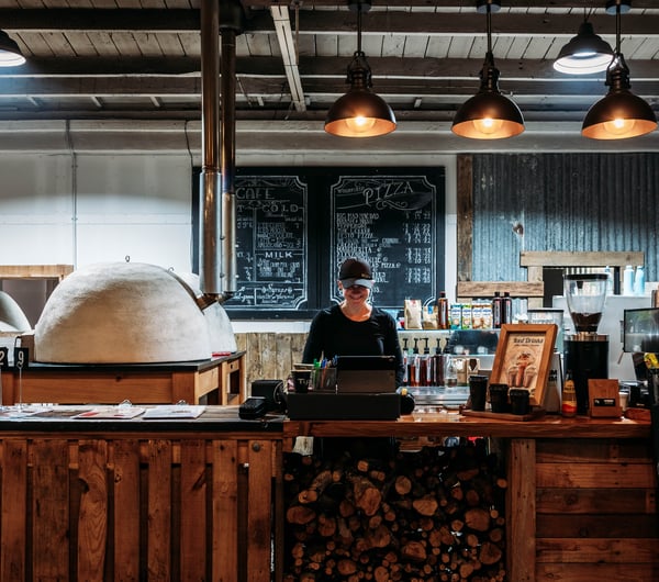 Staff member standing behind front counter at Cambridge Lane.