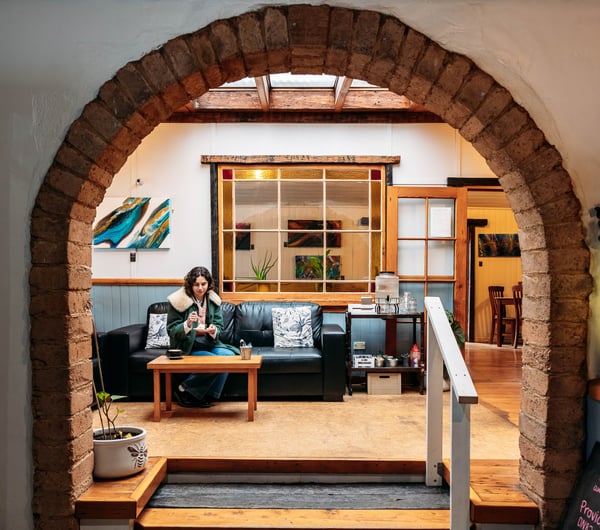 A woman sitting on a couch in a cafe.