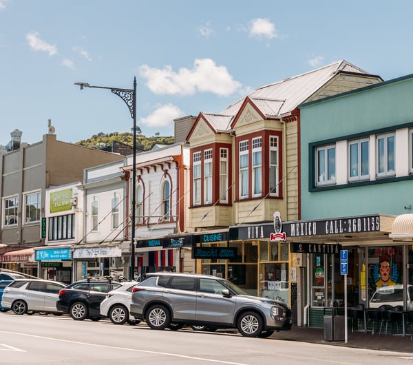 A row of old buildings with colourful facades along a street.