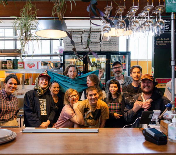 A group of people posing for the camera behind a bar.