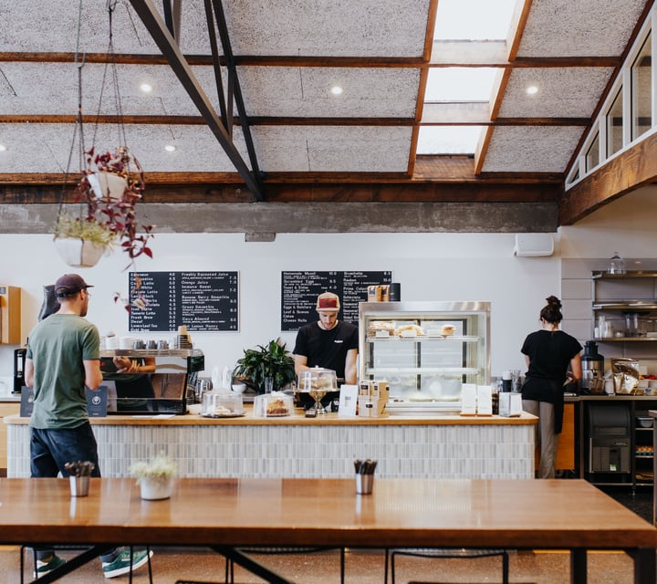 Two employees working behind the cafe counter at Allpress Espresso in Christchurch.