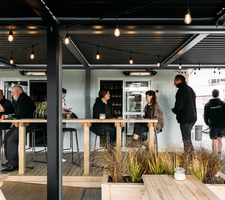 Customers chatting at tables outside the cafe.