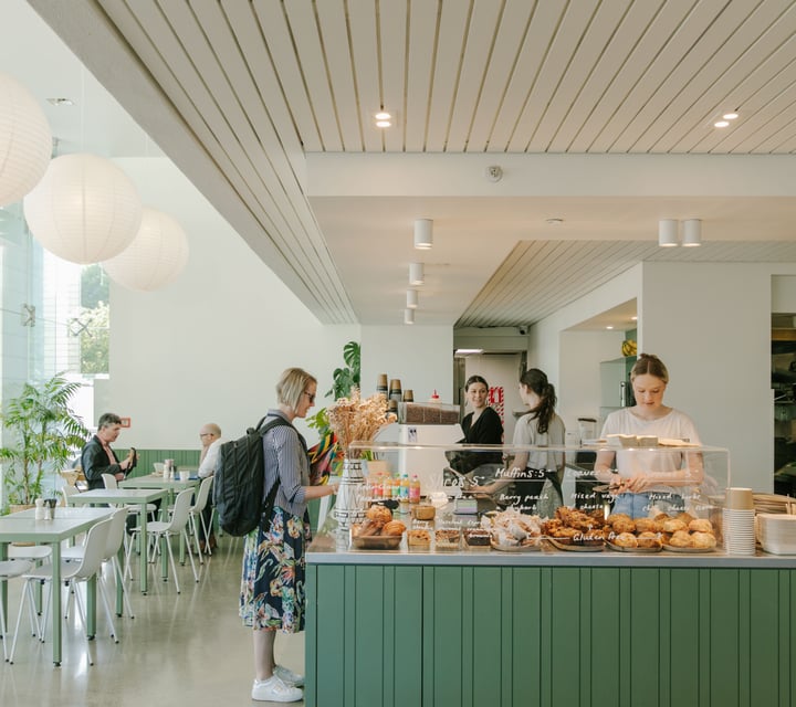 A customer ordering at the white and green counter at Doubles cafe Christchurch.