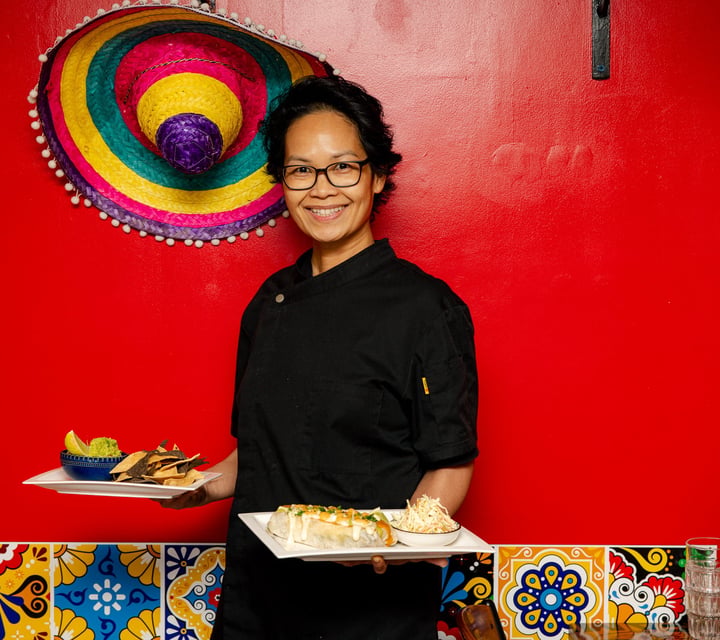 Plates of food being delivered by a server at El Mexicano Zapata Express.