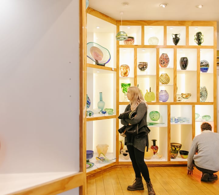 Woman looking around the gallery at flamedaisy.