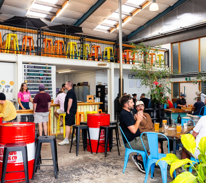 Groups of people drinking inside Renegade Brewing Co's industrial space in Christchurch