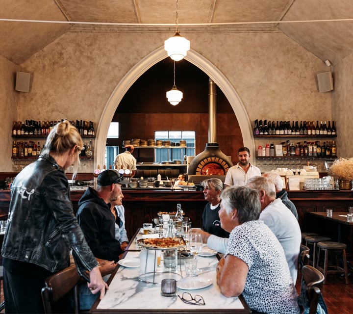 Customers dining at a large table at Sundays in Queenstown.