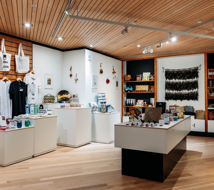 Gift shop with products on shelves and display tables at Waikato Museum.
