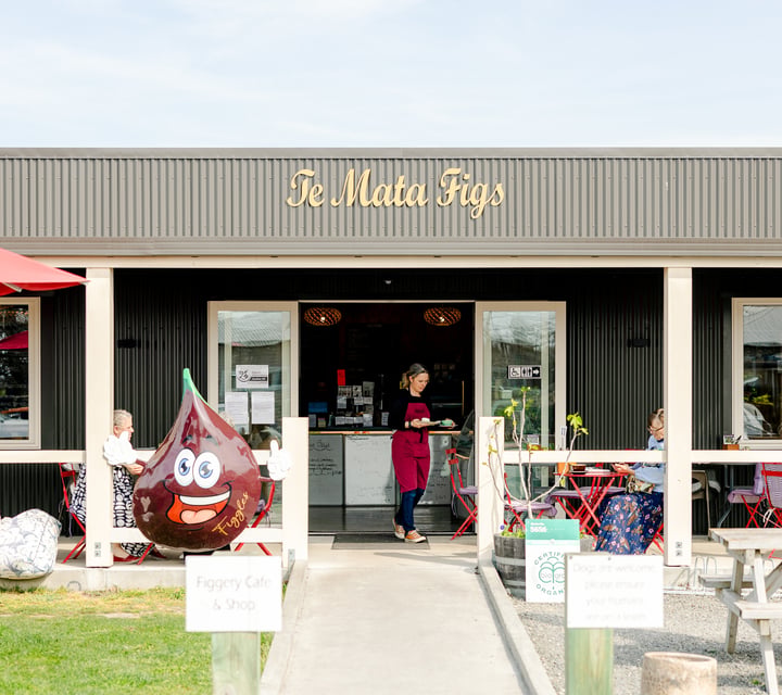 Entrance to Te Mata Figs Cafe and Shop with waiter carrying coffees out to diners sitting at outdoor tables