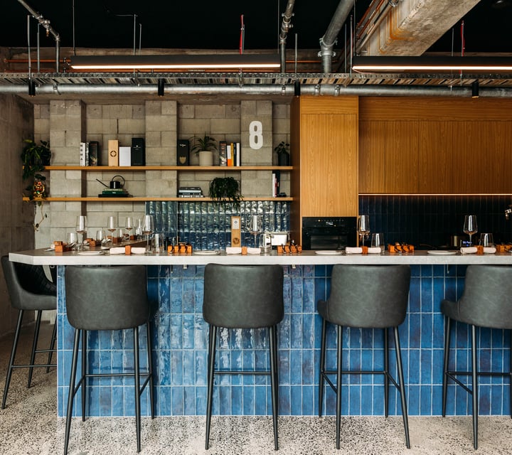 High seats placed around a kitchen and bar area.