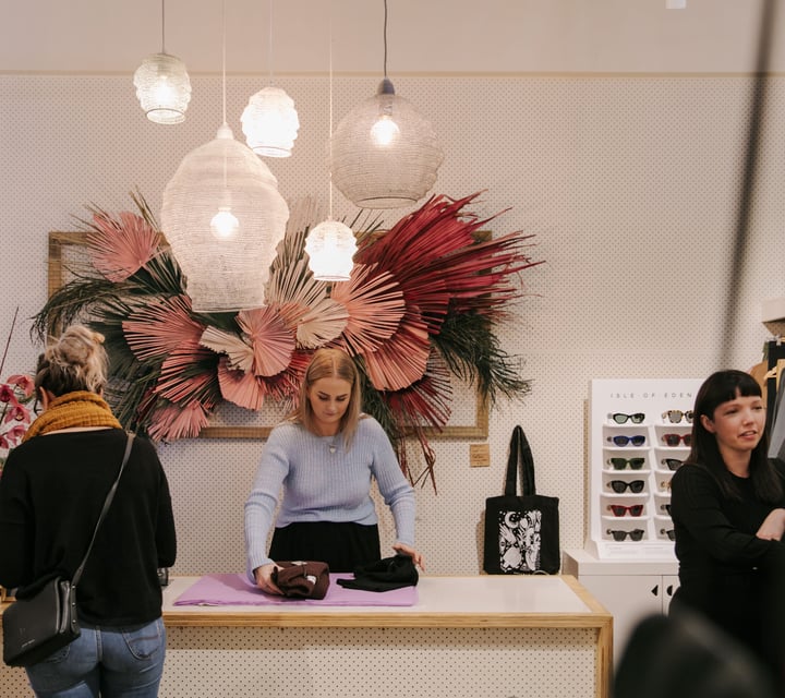 Woman serving a customer at the counter at Trouble and Fox.