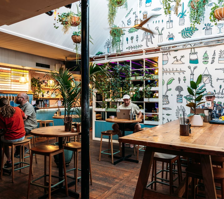 Customers dining inside a brightly decorated Queenstown cafe.