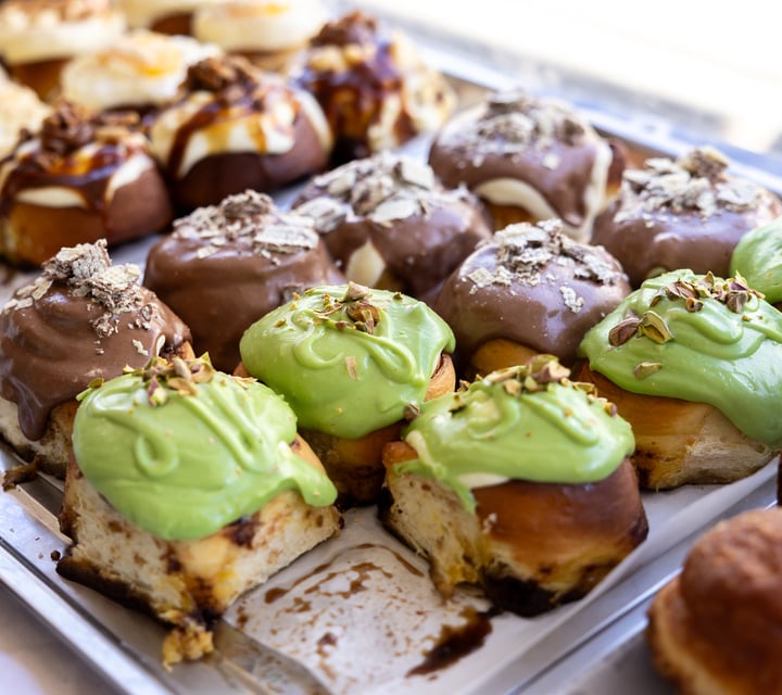 Tray of cinnamon rolls with colourful icing at Zoyi.