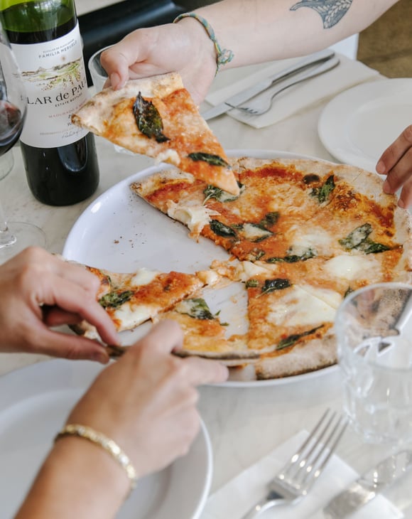 Diners enjoy a slice of pizza from one of the 10 best pizza spots in Christchurch.