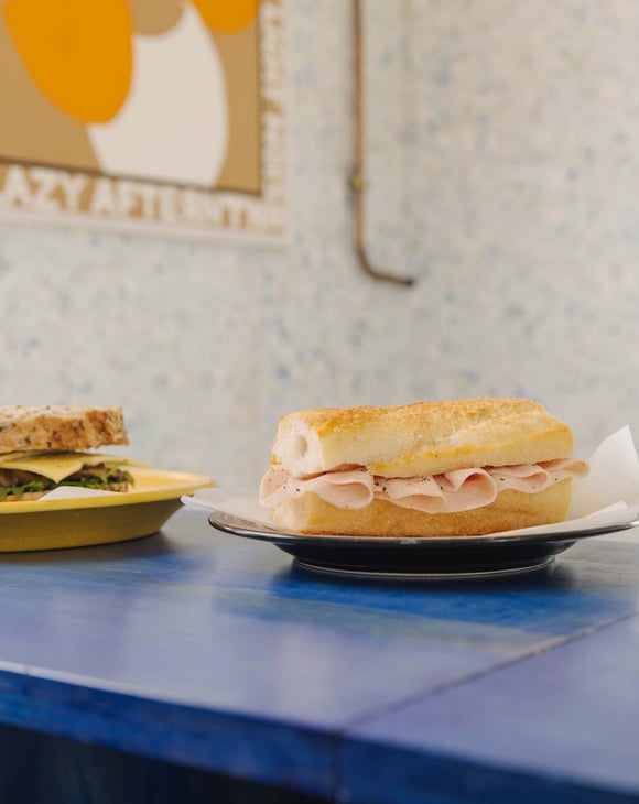 Two simple sandwiches placed next to each other on blue table at Odds in Christchurch
