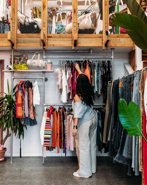 Customer browsing clothing racks in a vintage store.