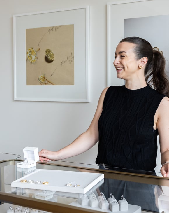 Shop assistant behind a jewellery counter.