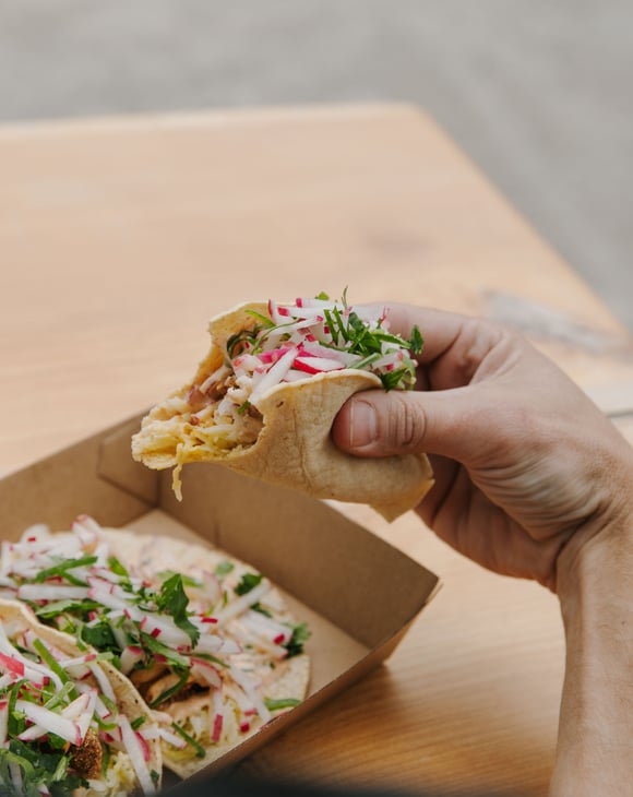 A hand holding a taco.