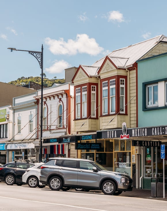 A row of old buildings with colourful facades along a street.