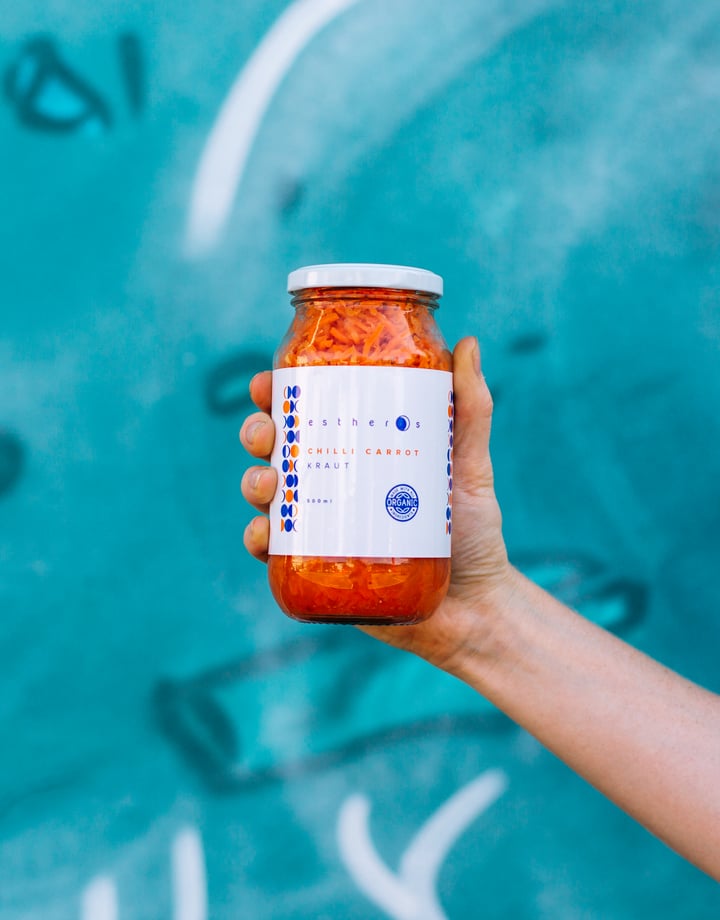 Jar of pickle against a blue wall.