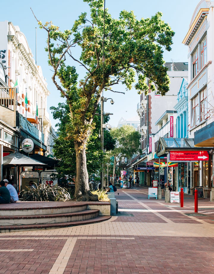 People sitting on tables on Cuba Street in Wellington.