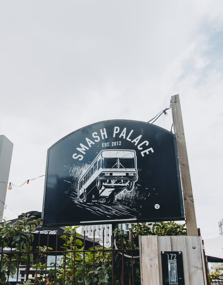 A large black and white sign for Smash Palace on High Street.
