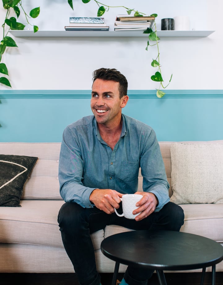 A photo of Matt Stark sitting on a couch.