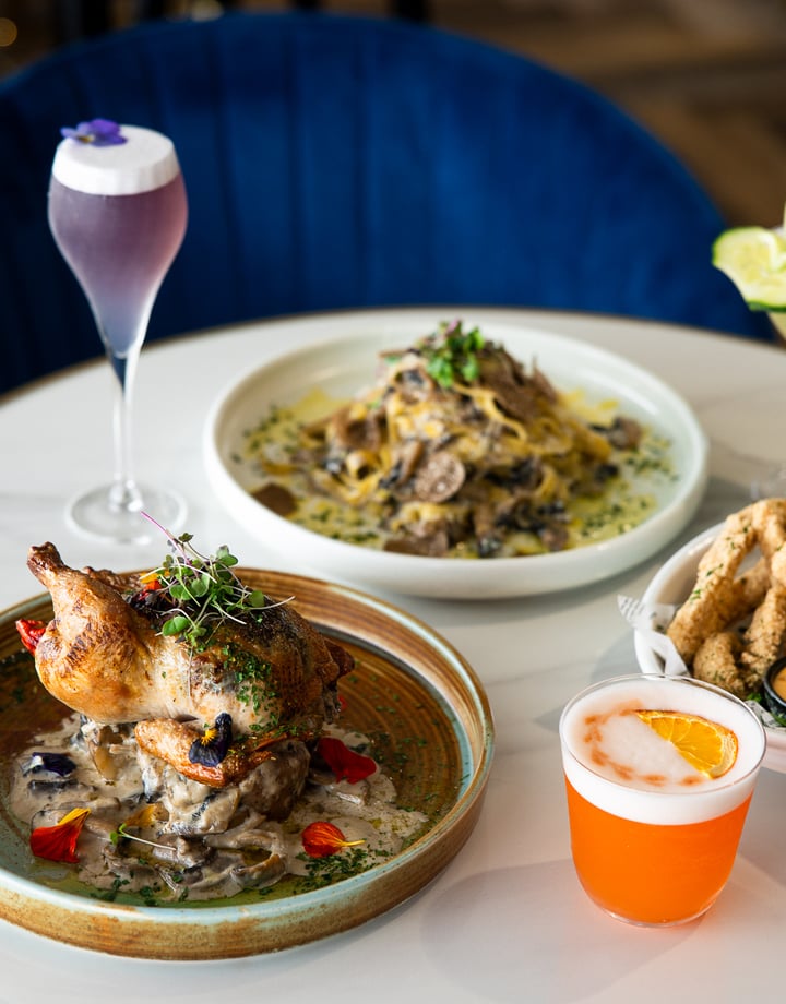 Plates of food and cocktails on a table.