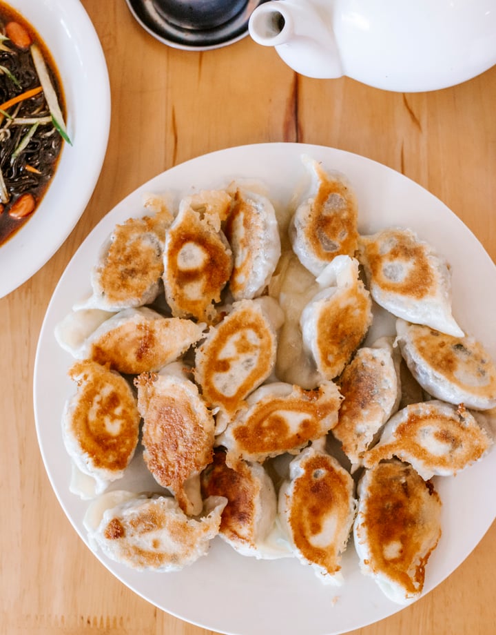 A flatlay of a plate of dumplings on a table.