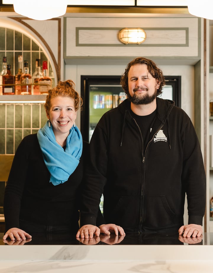 A man and woman standing behind a bar counter in Wellington.