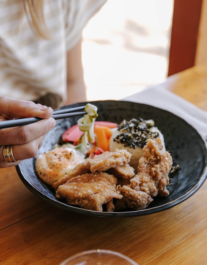 A customer is eating a dish at Sime's Kitchen.