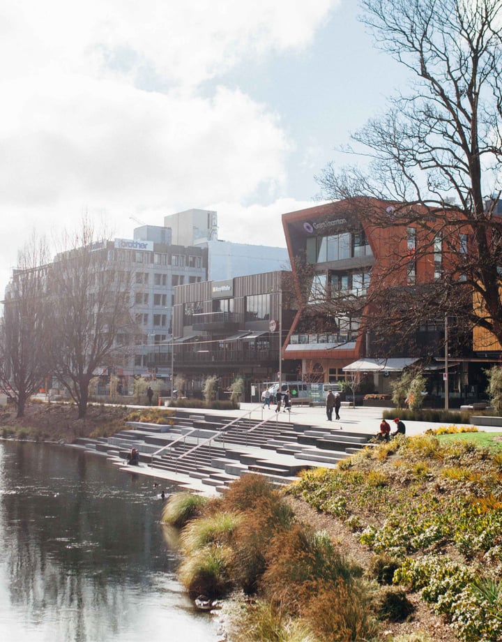 Buildings lined up alongside a river on a sunny day.