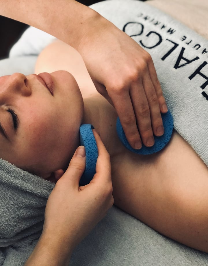 A woman draped in a blue towel getting a facial  at Total Body Concept in Christchurch.