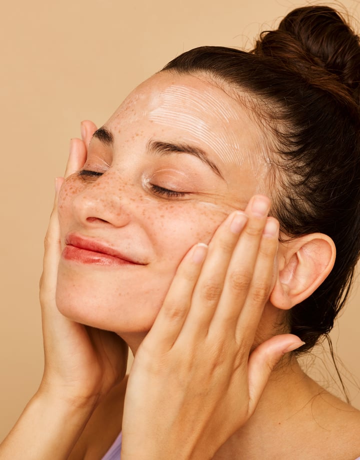 A woman pushing hands onto their face.
