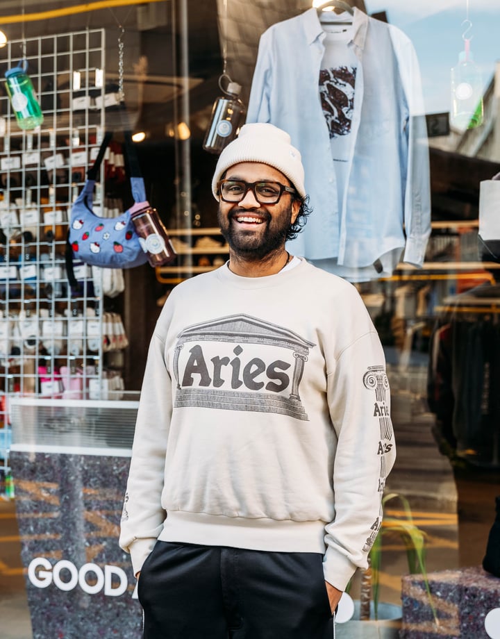 A man wearing a casual clothes smiling to camera outside a shop in Wellington.