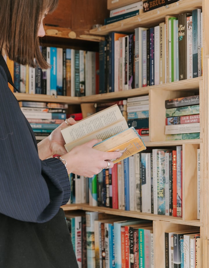 A woman with a short brown bob reading an old book.