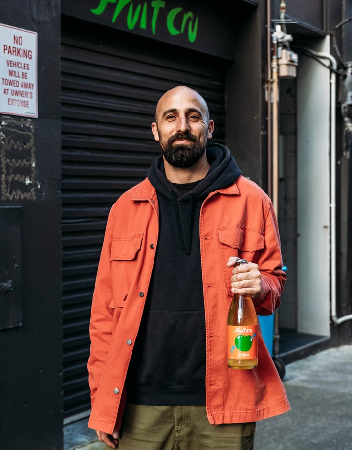 Cosmo holding a bottle of Fruit Cru.