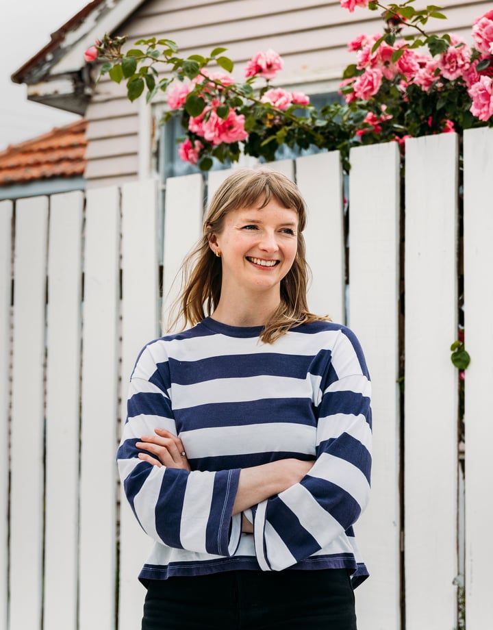 A woman wearing a stripped top smiling.
